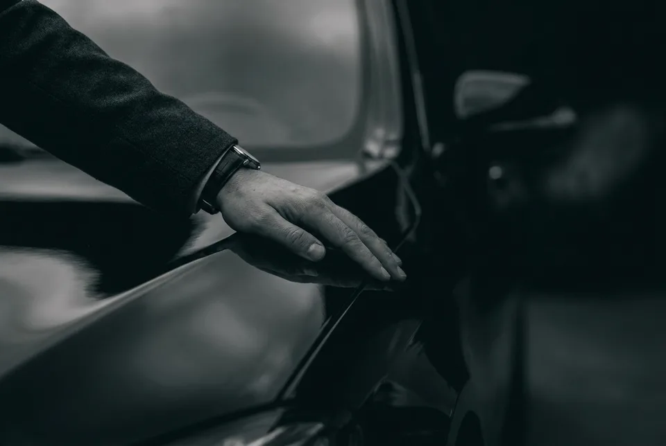 Hand inspecting the paint finish of a black car